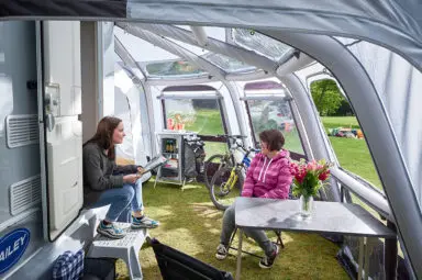 Mum and daughter in the awning of their Discovery caravan discussing what clubs offer