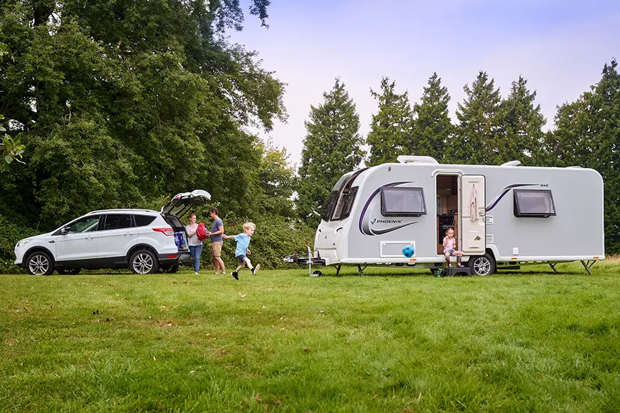 Family setting up their caravan while children play