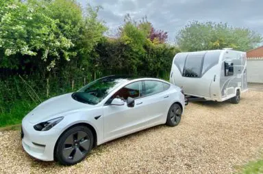 A Tesla electric car towing a Bailey Discovery D4-2 caravan