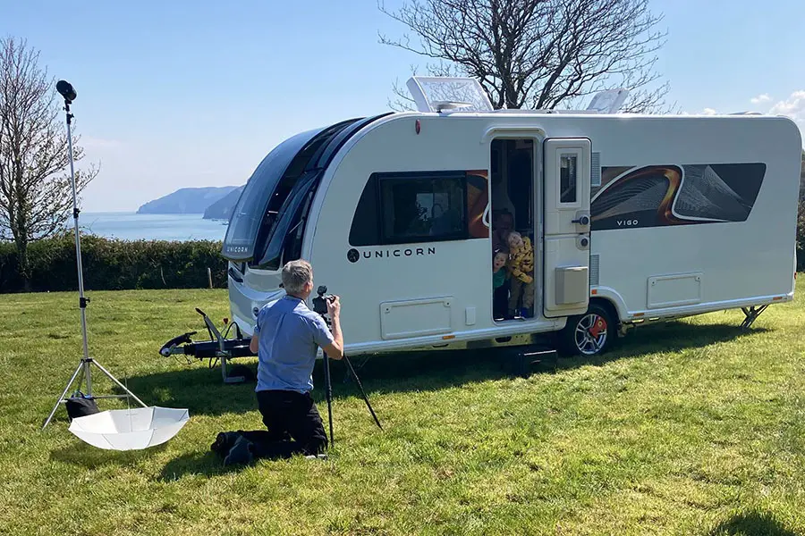 Photographer taking photos of children in the doorway of a caravan