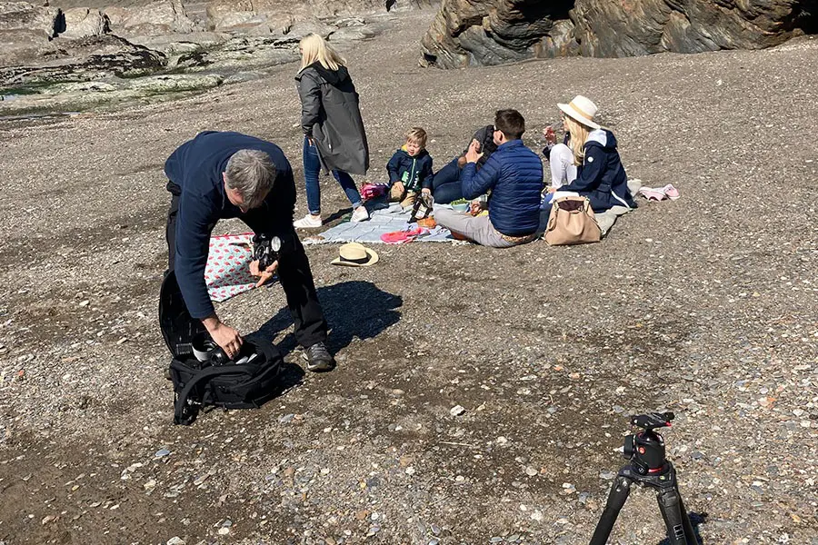 Photographer setting up to take photos of beach picnic