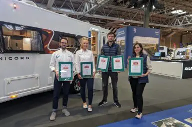 Bailey of Bristol employees holding their certificates at a caravan event show.
