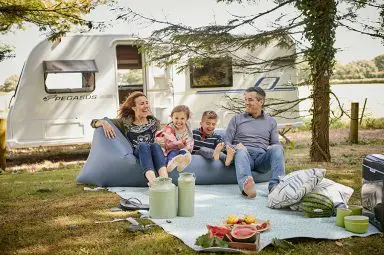 A family having a picnic in front of their Bailey Pegasus GT70 caravan