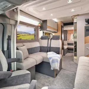 Interior view of the Bailey Adamo XL-DL motorhome, showing spacious lounge with plush seating, overhead lighting, and modern fittings.