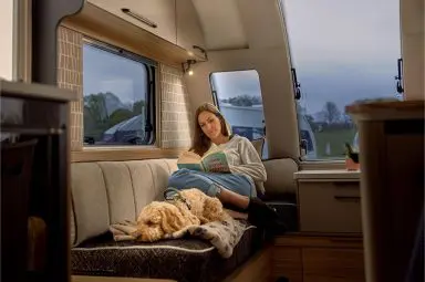 A woman relaxing with her dog in the Bailey of Bristol Pegasus Grande Black Edition