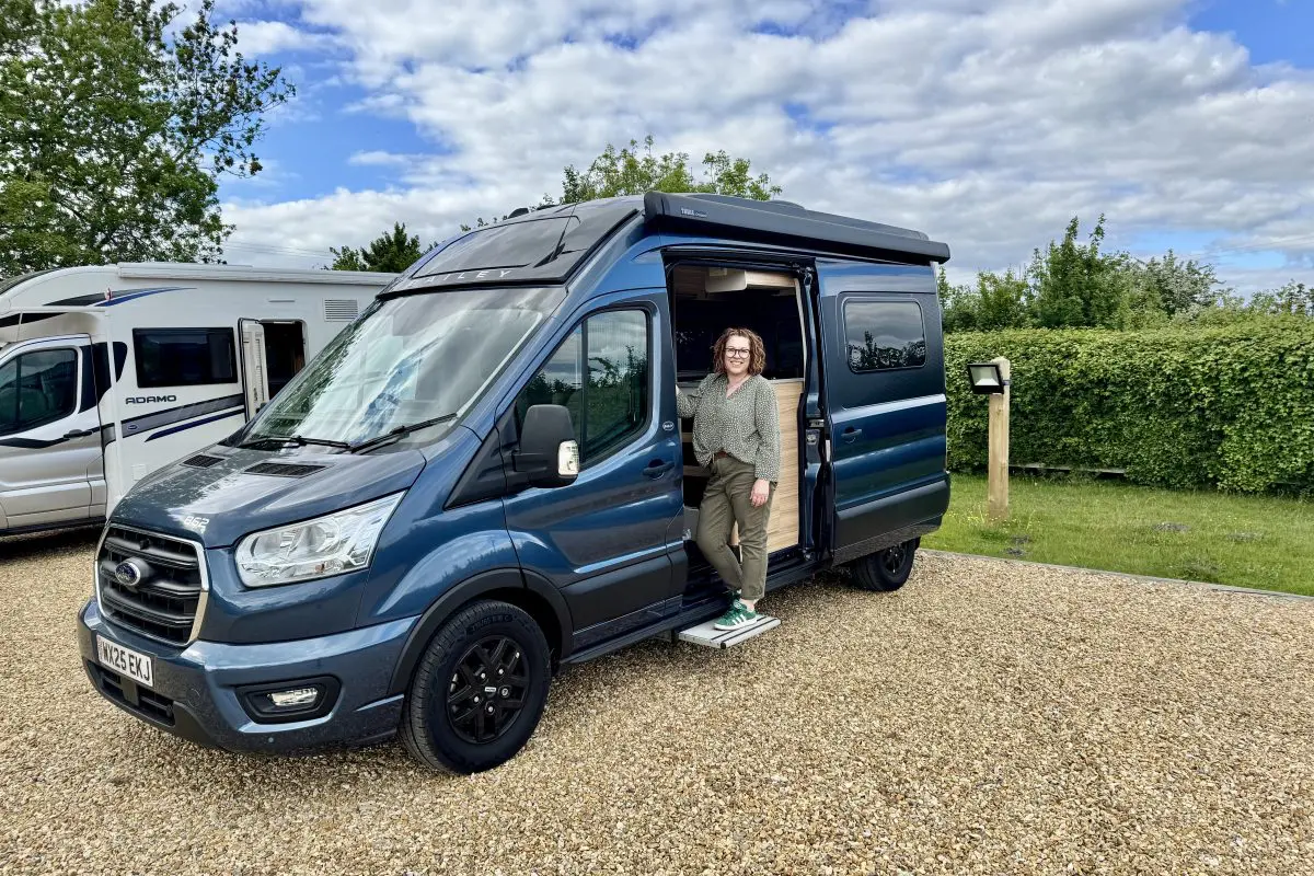 Bailey Endeavour B62 campervan parked at a Brit Stops location in with a traveller standing by the open side door.