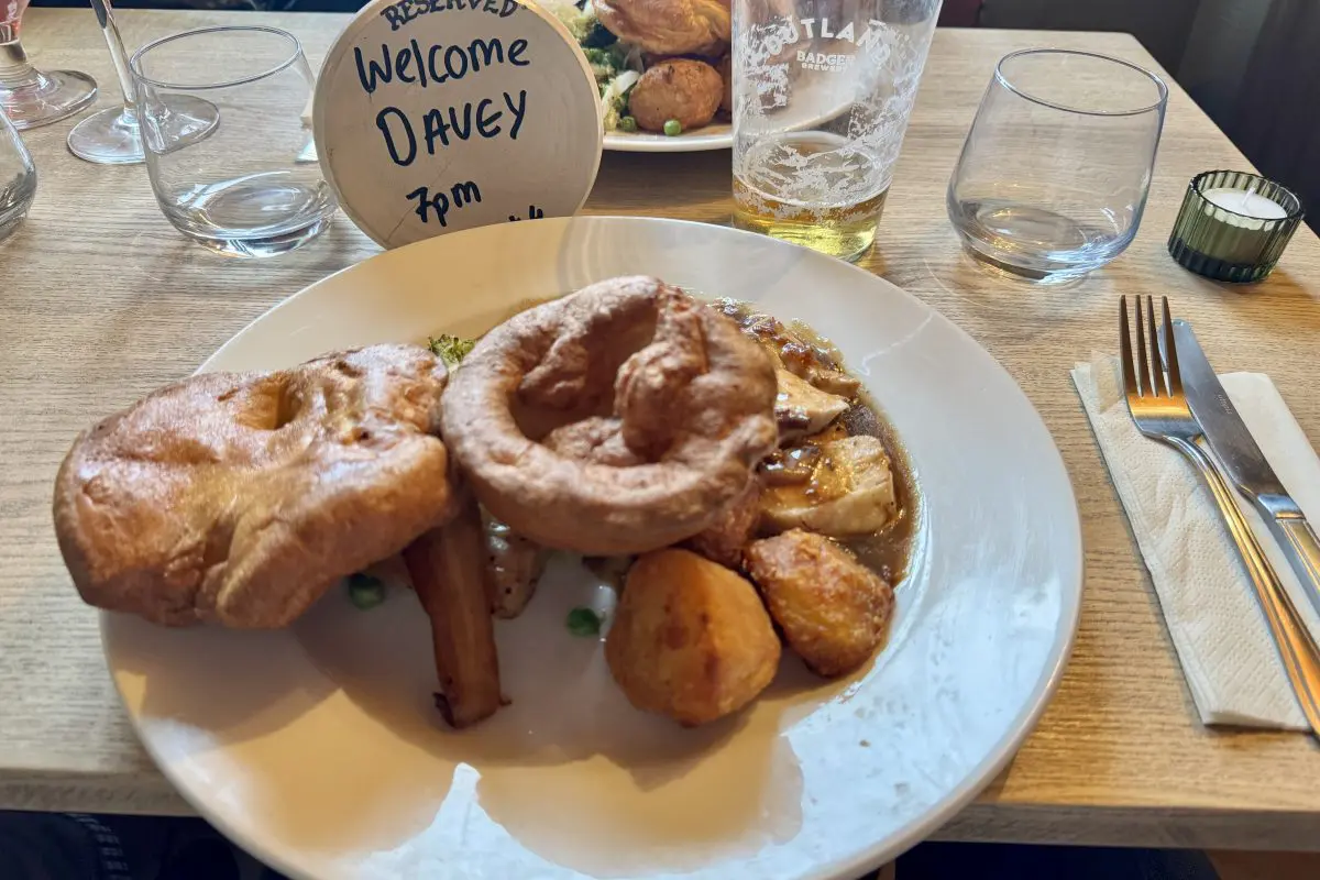 Sunday roast dinner on a pub table with a reserved sign welcoming Brit Stop guests at The Halfway Inn in Dorset