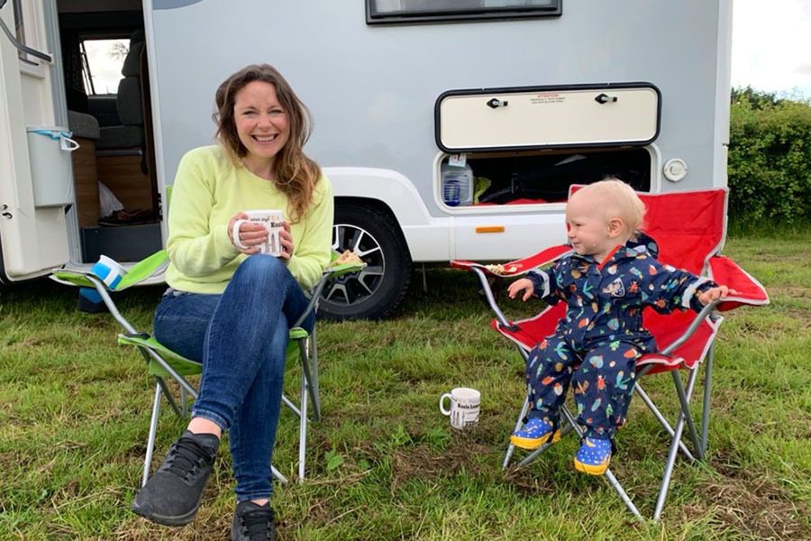 Mum and toddler sitting outside motorhome