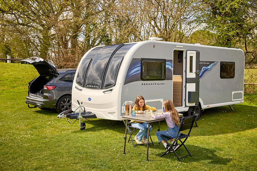 Children playing a game outside their family's Bailey Pegasus Grande Black Edition