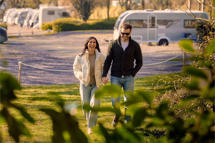 A couple walking through a countryside campsite